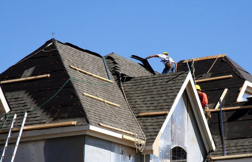 Men working on roof to install new shingles