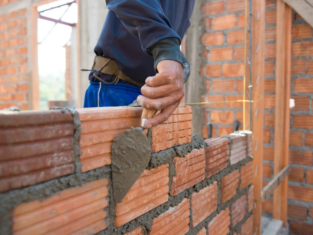 Man performing residential brick masonry work on home