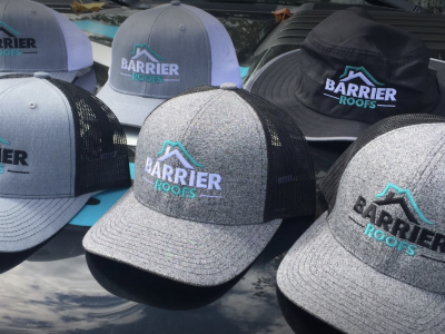 Branded Barrier Roofs hats sitting on table